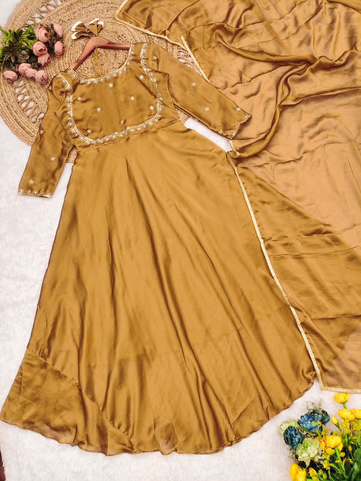 A stunning honey-gold Anarkali dress crafted in rich Chinnon silk fabric, featuring a graceful flared silhouette. The bodice is adorned with delicate golden embroidery and tiny floral motifs, complemented by a square neckline and full-length sleeves for an elegant finish. The subtle sheen of the fabric adds a regal charm, making it perfect for festive occasions, weddings, and traditional celebrations. Paired with statement earrings, this outfit exudes timeless sophistication. ✨ - Image 2