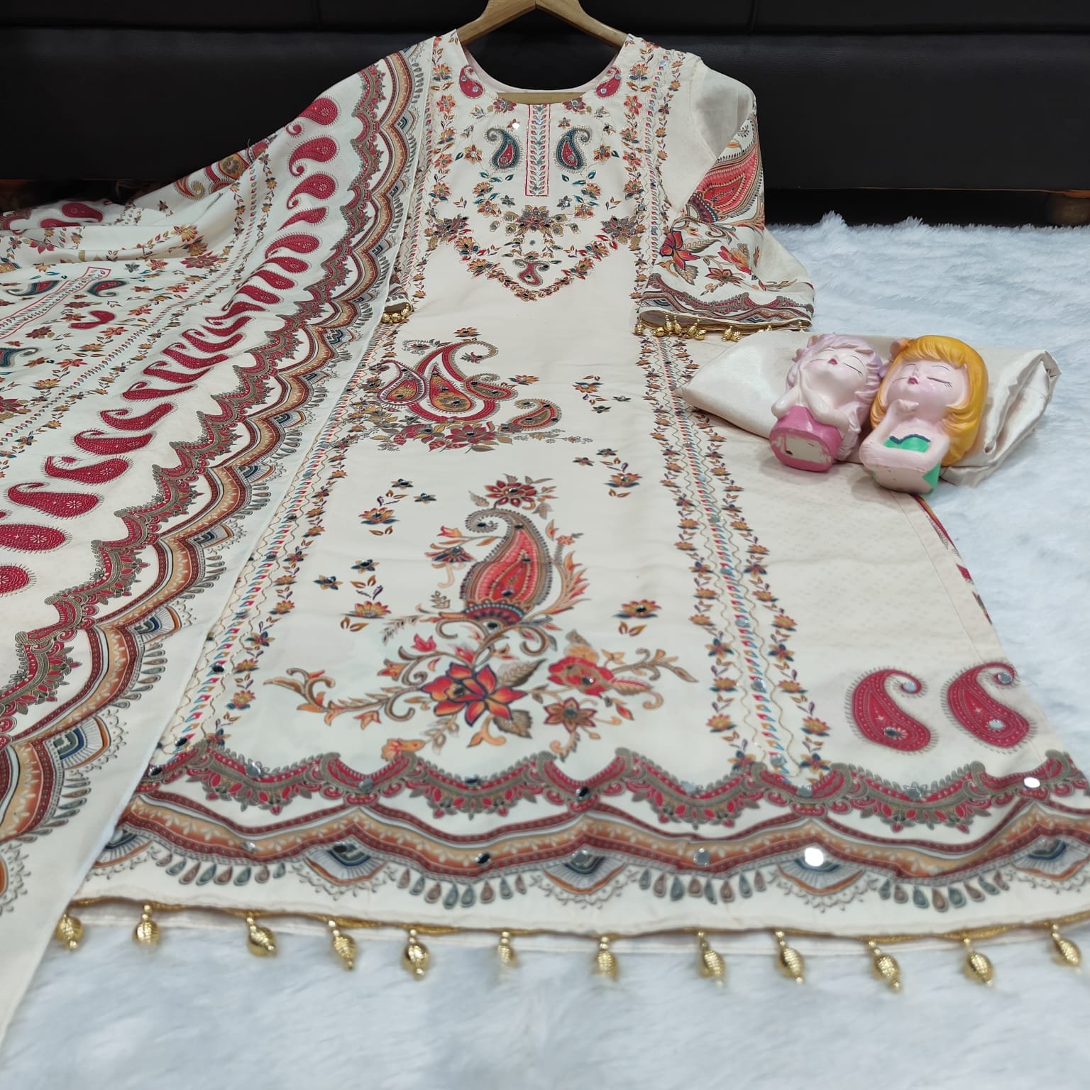 STITCHED This outfit is a beautiful example of a-style suit in a soft cream or off-white base, featuring vibrant traditional motifs. Here is a detailed description you can use for a product listing or social media post: - Image 2