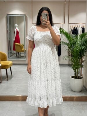 The dress features a smocked bodice, dainty puff sleeves, and a tiered midi silhouette covered in the sweetest micro-floral print. Ideal for brunch, picnics, or golden hour strolls.