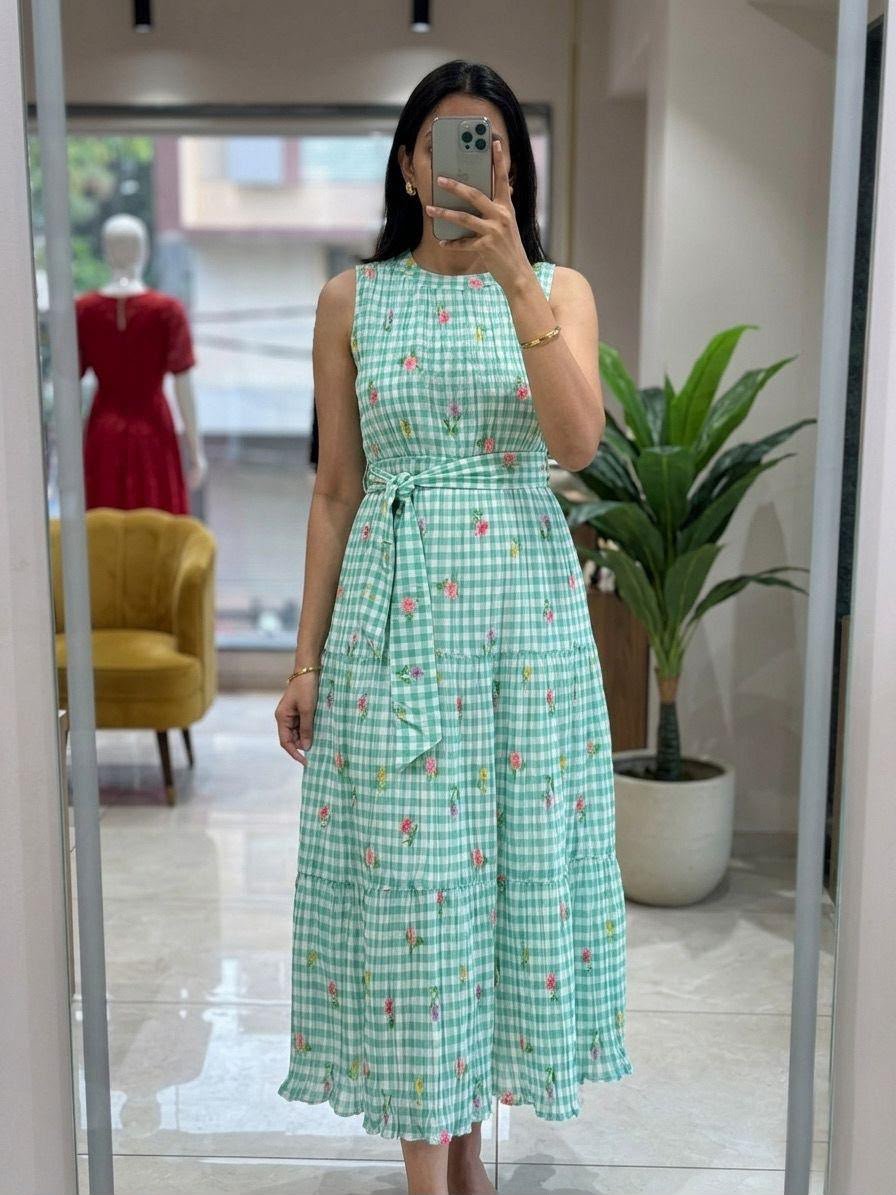 The dress has a high halter-style neckline with delicate pleating, which adds texture and structure to the bodice. - Image 2