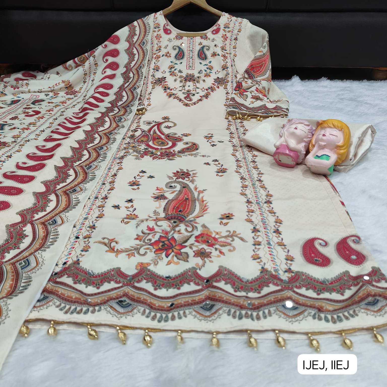 This outfit is a beautiful example of a-style suit in a soft cream or off-white base, featuring vibrant traditional motifs. Here is a detailed description you can use for a product listing or social media post: - Image 2